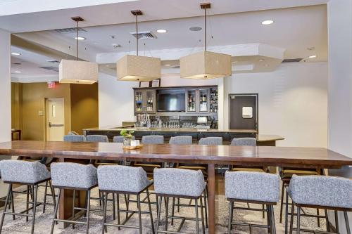 Hilton Garden Inn Phoenix Airport North في فينكس: غرفة طعام كبيرة مع طاولة وكراسي كبيرة