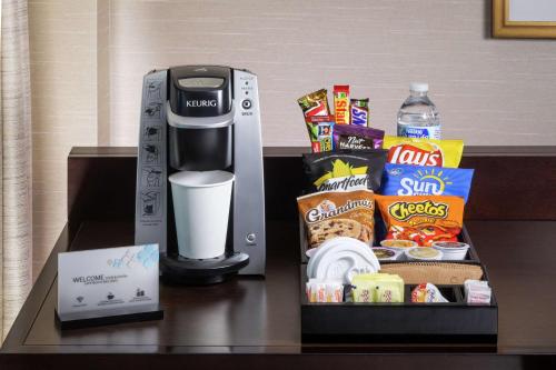 a coffee maker and a box of snacks on a table at Hilton Garden Inn Phoenix Airport North in Phoenix