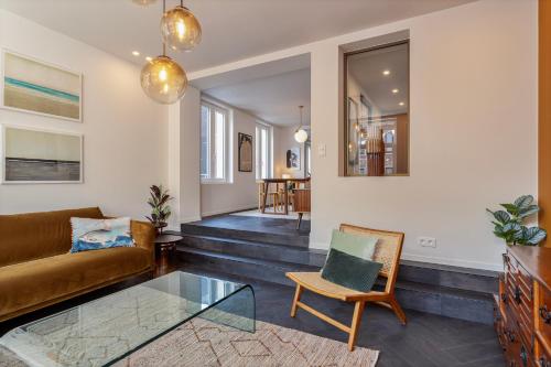 een woonkamer met een bank en een glazen tafel bij Uma's Urban Lounge in Mechelen