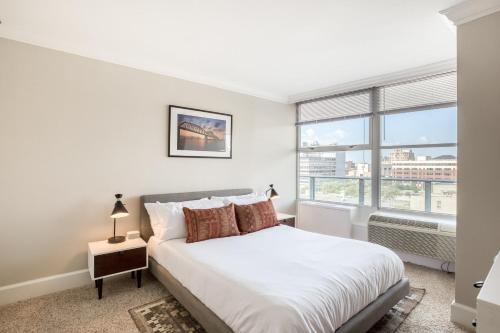 a bedroom with a bed and a large window at CozySuites 800 Tower 2BR w sky pool gym 28 in Louisville