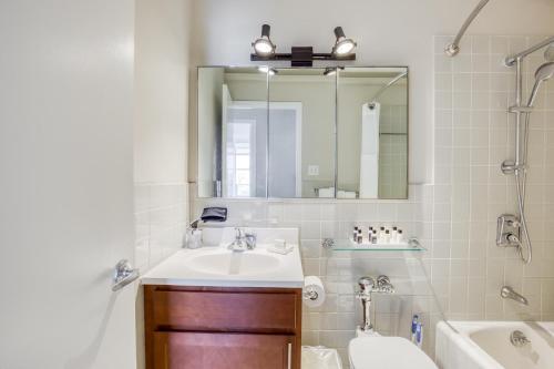 a bathroom with a sink and a tub and a mirror at CozySuites 800 Tower 2BR w sky pool gym 28 in Louisville