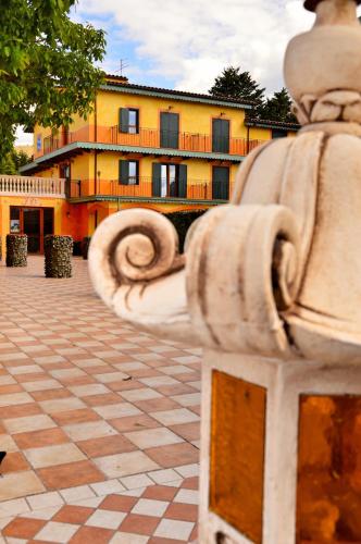 a stone bench in front of a yellow building at Hotel La Valle dell'Aquila in LʼAquila