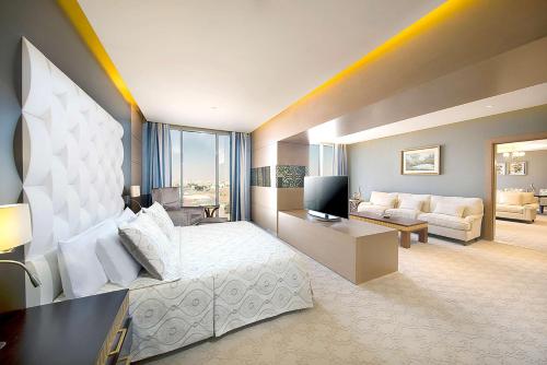 a bedroom with a bed and a living room at Hilton Garden Inn Tabuk in Tabuk