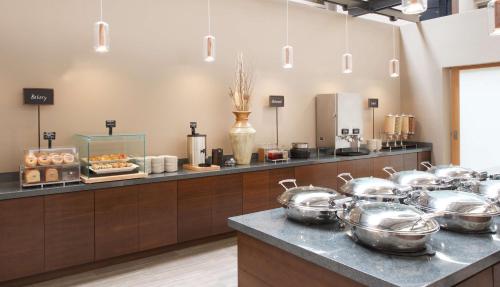a buffet line with many pots and pans at Embassy Suites by Hilton Seattle North Lynnwood in Lynnwood