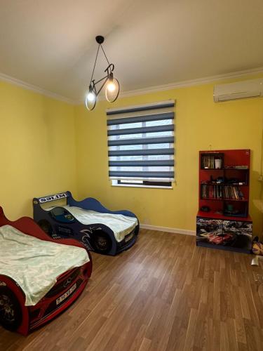 um quarto com uma cama e um carrinho de brinquedo no chão em Villa SM em Baku