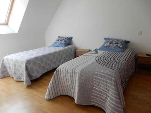 two beds sitting next to each other in a room at Maison 3 chambres 120m2 3km ploermel in Ploërmel