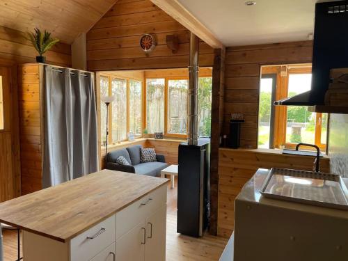 eine Küche mit einem Kühlschrank und einem Sofa in einem Zimmer in der Unterkunft Le Chalet in La Meilleraie-Tillay