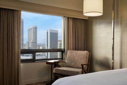 a hotel room with a bed and a chair and a window at Hilton Denver City Center in Denver
