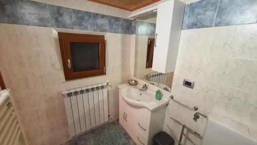 a bathroom with a sink and a tv in it at Spicchio di Luna - Casa Vacanze in Albiano