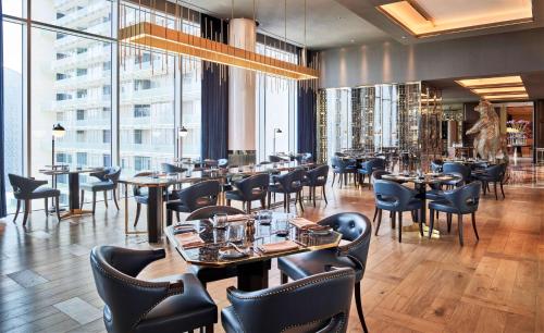 a restaurant with tables and chairs and windows at Waldorf Astoria Dubai International Financial Centre in Dubai