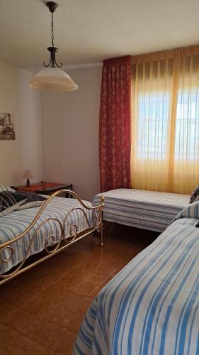 1 dormitorio con 2 camas y ventana en La Beccaccia, en Baceno