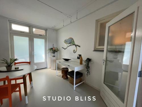 uma sala de jantar com uma mesa e uma janela em Studio Bliss em Oud-Gastel