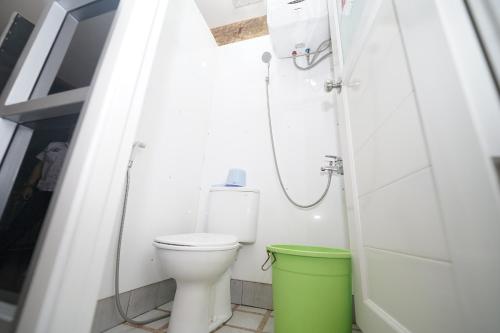 a bathroom with a toilet and a green trash can at Hotel Soreang in Bandung