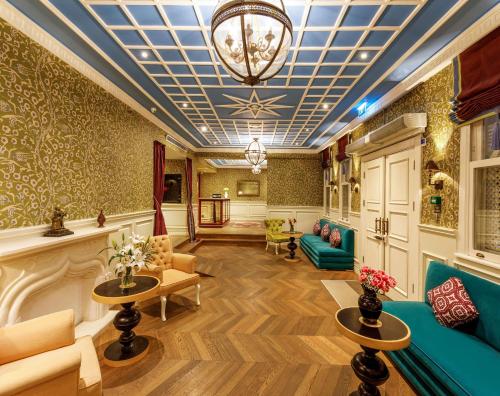 een lobby met een bank, tafels en een kroonluchter bij Hagia Sofia Mansions Istanbul, Curio Collection by Hilton in Istanbul