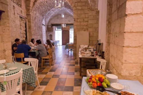 Al-Hakim Boutique Hotel Old Town Nazareth في الناصرة: مجموعة من الناس يجلسون على الطاولات في المطعم