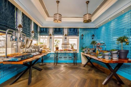 een grote keuken met blauwe betegelde muren en tafels bij Hagia Sofia Mansions Istanbul, Curio Collection by Hilton in Istanbul