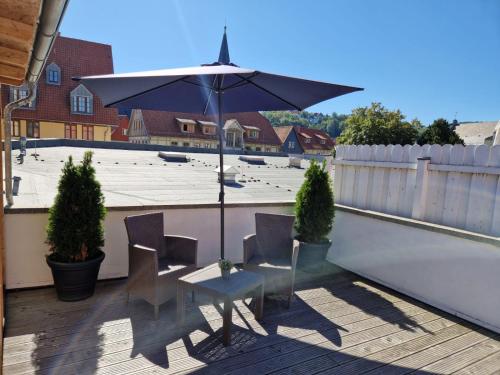 a table and chairs with an umbrella on a patio at Ferienwohnung zum Marktplatz in Wernigerode