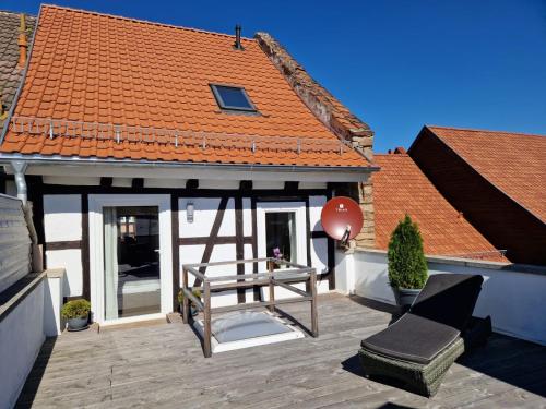 a house with a deck with a bench and a roof at Ferienwohnung zum Marktplatz in Wernigerode
