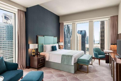 Habitación de hotel con cama y ventana grande en Wyndham Grand Doha West Bay Beach en Doha