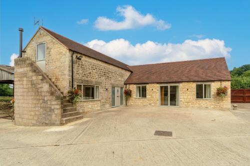 a brick building with a driveway in front of it at Owls Nest Barn in Harescombe