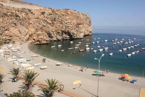 a beach with a bunch of boats in the water at Hotel Embarcadero de Calahonda de Granada in Calahonda