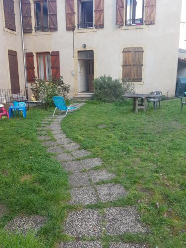 un camino de piedra frente a un edificio con una mesa y un banco en Élégant F2 de 70m2 à 1km du centre ville., en Metz