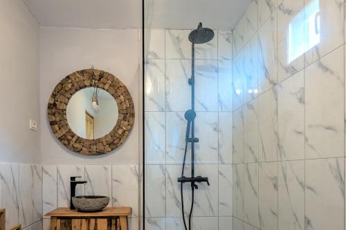 a bathroom with a shower and a mirror at Satul de vacanta Cuibul Lupilor in Ciucea
