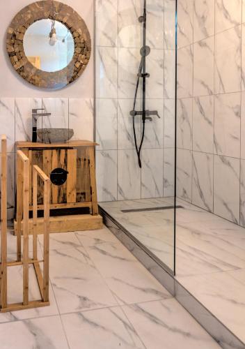 a bathroom with a shower and a mirror at Satul de vacanta Cuibul Lupilor in Ciucea