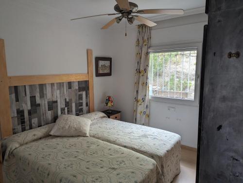 - une chambre avec un lit et un ventilateur de plafond dans l'établissement Villa Carmen, à Torrox Costa