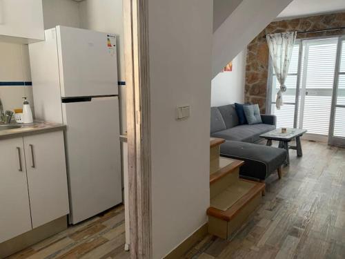 a kitchen and living room with a refrigerator and a couch at Casa Dúplex en Puerto de Alcudia in Alcudia