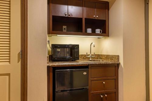 a small kitchen with a sink and a microwave at The Blakely by LuxUrban, Trademark Collection by Wyndham in New York