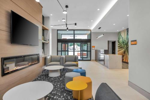 un vestíbulo de oficina con chimenea y TV en La Quinta Inn & Suites by Wyndham San Jose Silicon Valley, en San José