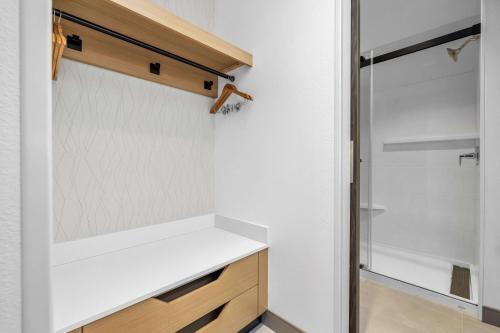 a small kitchen with white shelves and a glass door at La Quinta Inn & Suites by Wyndham San Jose Silicon Valley in San Jose