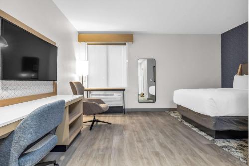a hotel room with a bed and a desk and chairs at La Quinta Inn & Suites by Wyndham San Jose Airport-Downtown in San Jose