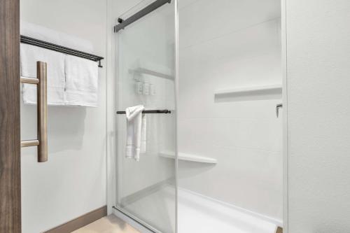 a glass shower door in a white bathroom at La Quinta Inn & Suites by Wyndham San Jose Airport-Downtown in San Jose