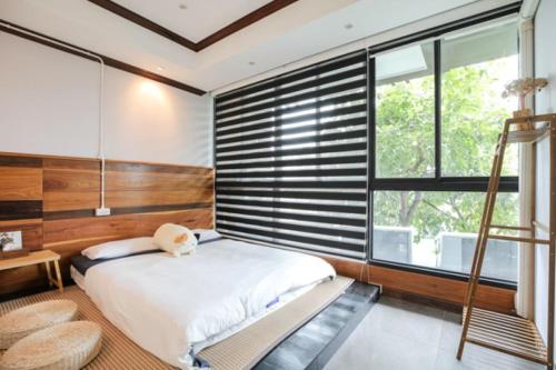 a bedroom with a bed and a large window at Arbor's house in Chiang Mai