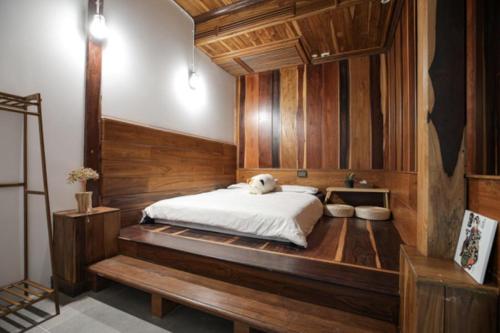 a bedroom with a large bed with wooden walls at Arbor's house in Chiang Mai