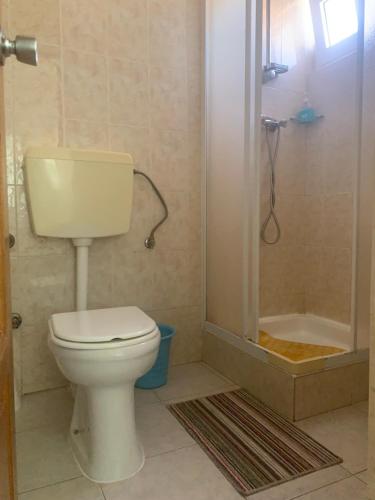 a bathroom with a toilet and a shower at Residencial Pôr do Sol in Porto Novo