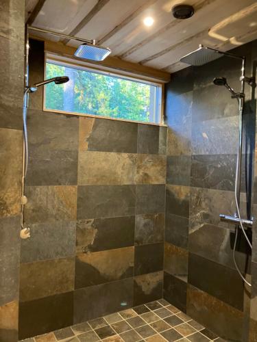 een badkamer met een douche en een raam bij Havu Resort Laajavuori, a calm and peasefull place in the forest near city in Jyväskylä