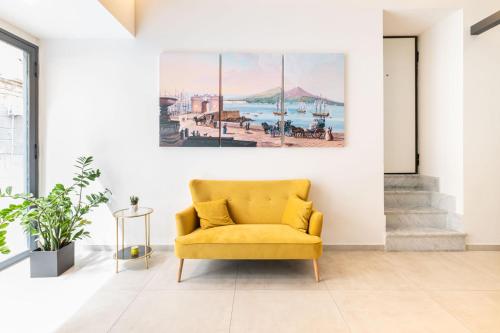 une chaise jaune dans un salon orné d'une peinture murale dans l'établissement Cortese, à Naples