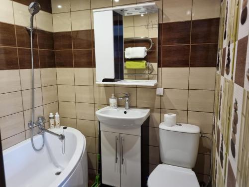 a bathroom with a sink and a toilet and a tub at Akmerenta 7 - 2 in Akmenė
