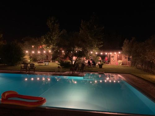 una piscina por la noche con una silla roja en Villa Giulia, en Castello del Lago
