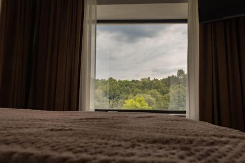 a bedroom with a bed and a large window at Vila MOON in Bezdead