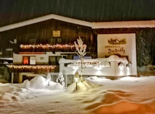a building with snow and lights in front of it at Gästehaus Judith in Längenfeld