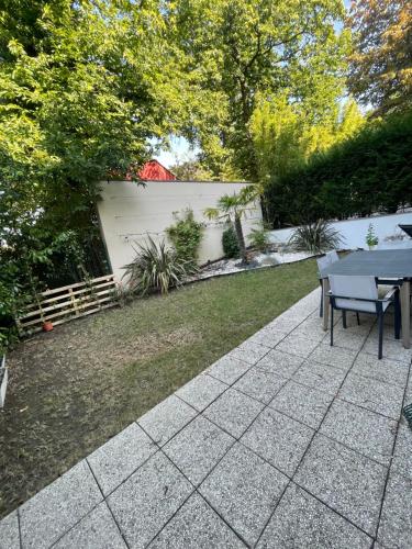 um pátio com uma mesa e uma cerca em Appartement proche de paris avec jardin em Meudon