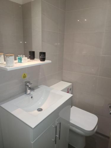 a white bathroom with a sink and a toilet at Harrogate Lifestyle Luxury Serviced ApartHotel in Harrogate