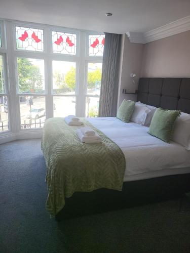 a bedroom with a large bed in front of windows at Harrogate Lifestyle Luxury Serviced ApartHotel in Harrogate