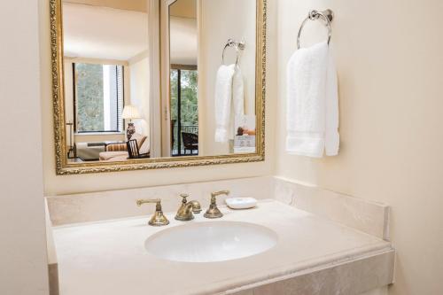a white bathroom with a sink and a mirror at Griffin Hotel, an official Colonial Williamsburg Hotel in Williamsburg