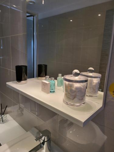 a shelf in a bathroom with a mirror at Harrogate Lifestyle Luxury Serviced ApartHotel in Harrogate