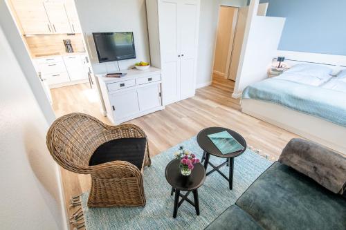 een kleine woonkamer met een bank en een bed bij Steger-Hüs Wohnung 20 in Rantum
